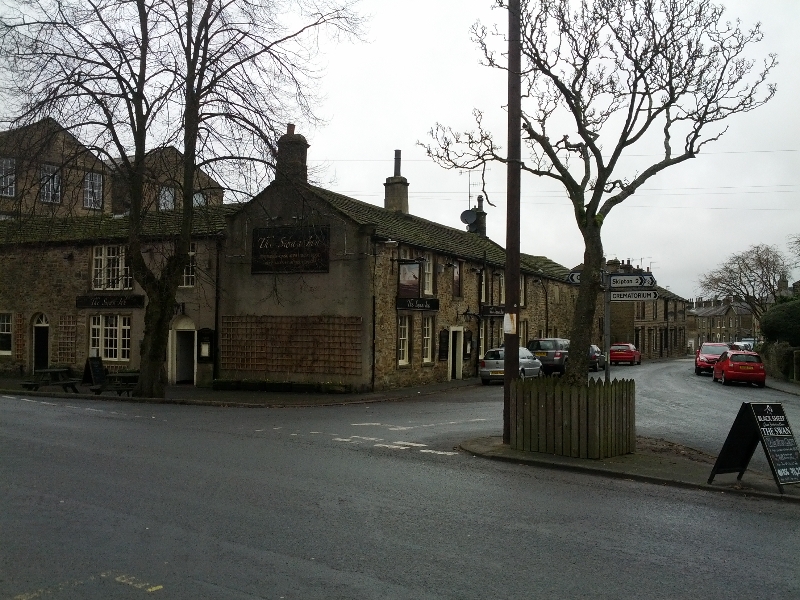 Stone buildings and street sign in Carleton, North Yorkshire, UK.
