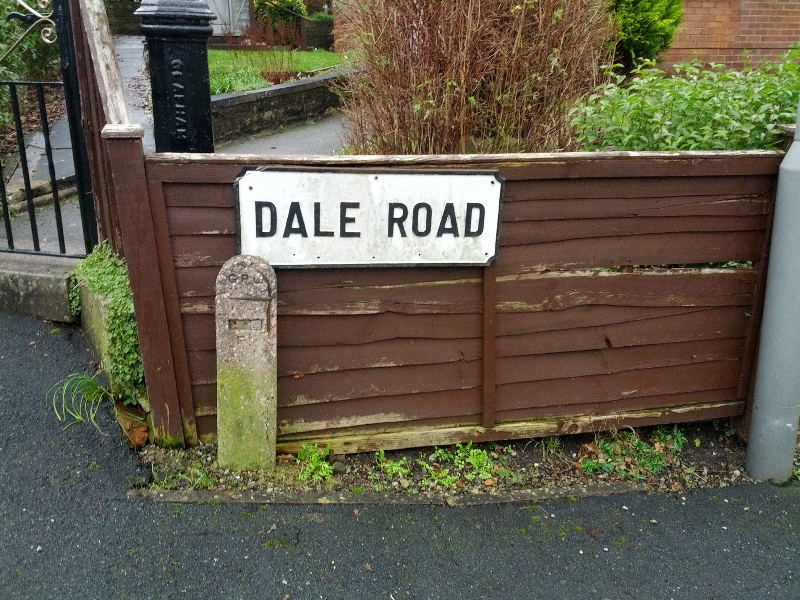 Dale Road sign in Carleton, North Yorkshire, UK, with a stone post.